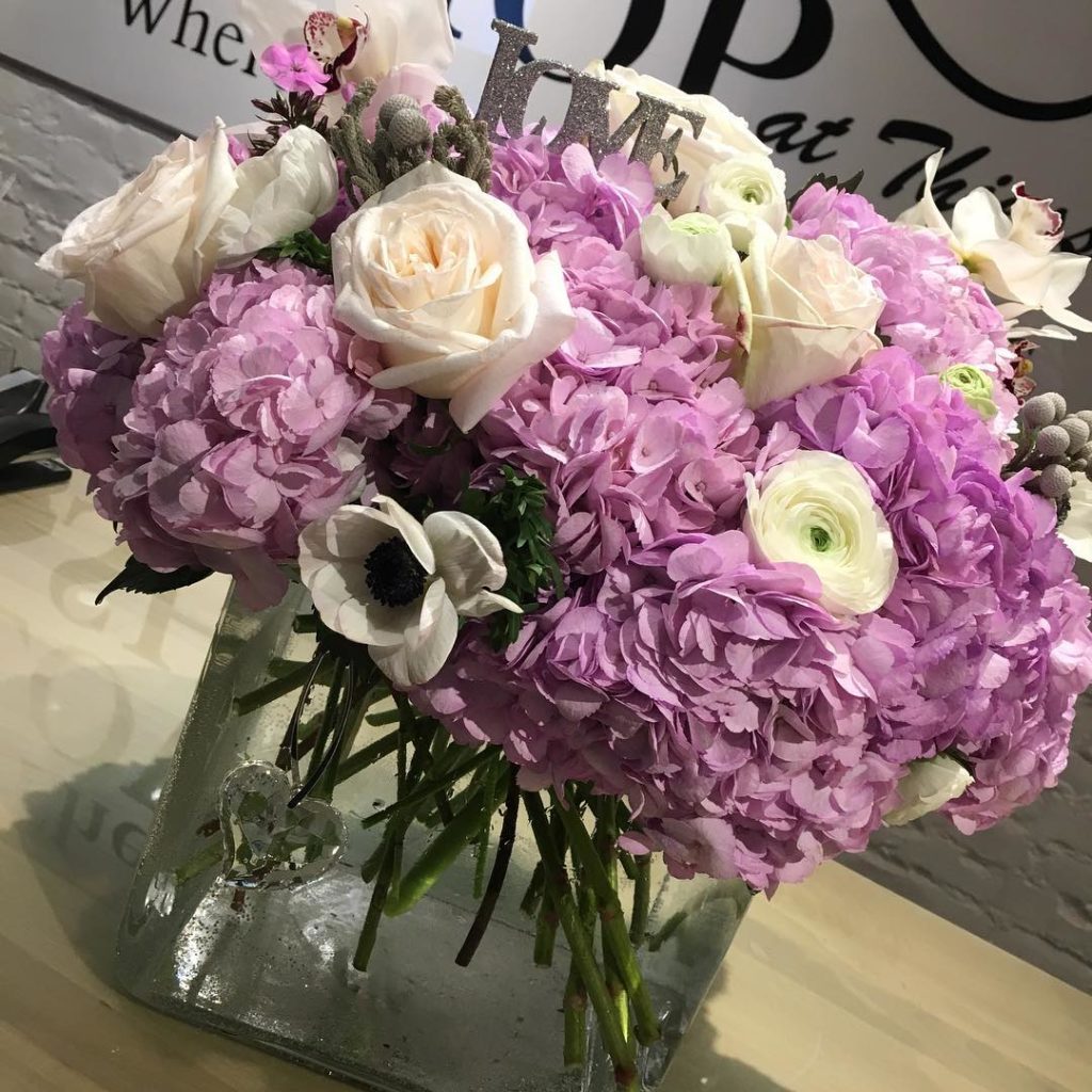 Purple hydrangeas with blush roses from The Flower Shop at Thiessen's. 