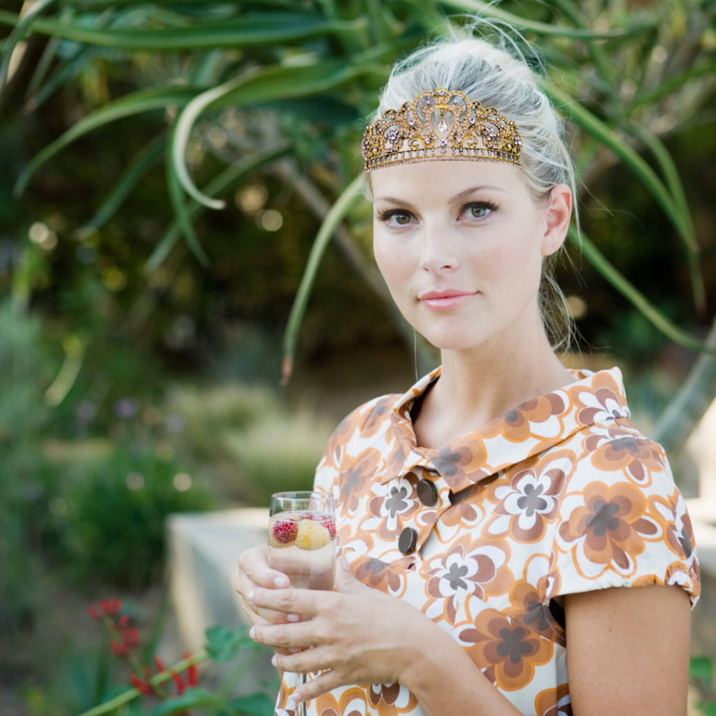 Women wearing crown holding a Royal cocktail made with Pelee Island Winery's Lola Secco Sparkling VQA Ontario and fresh fruit.